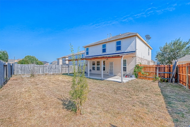 back of house featuring a patio and a yard