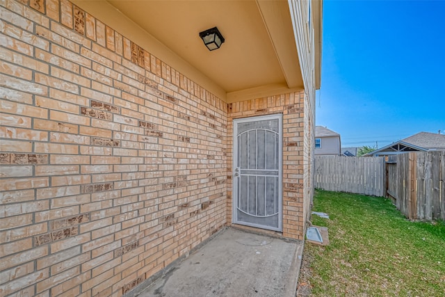 view of exterior entry with a yard