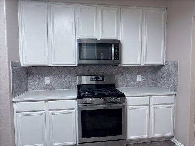 kitchen featuring white cabinetry, stainless steel appliances, and backsplash