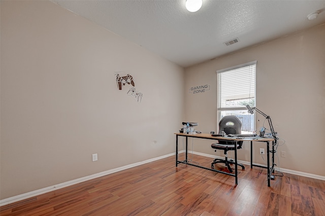 home office featuring a textured ceiling and hardwood / wood-style floors