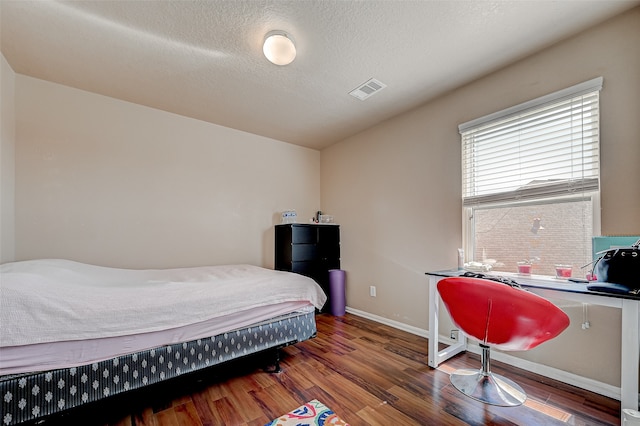 bedroom featuring a textured ceiling and dark wood-type flooring