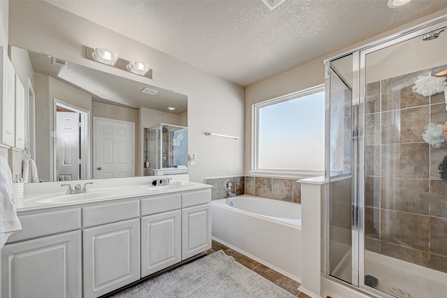 bathroom with dual vanity, shower with separate bathtub, tile patterned floors, and a textured ceiling