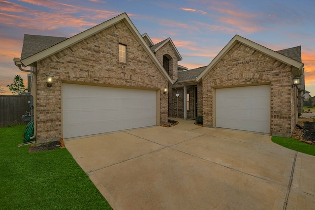 view of front of home with a garage and a lawn