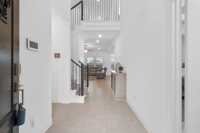 tiled entrance foyer with a high ceiling and ceiling fan