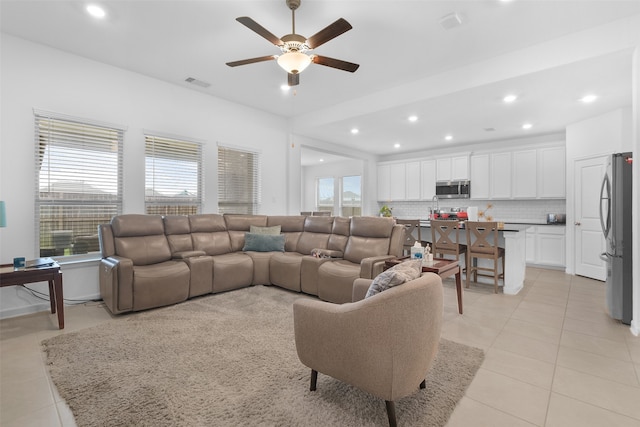 tiled living room with ceiling fan