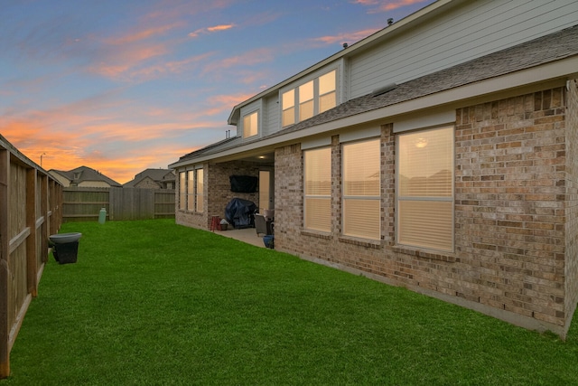 yard at dusk featuring a patio area