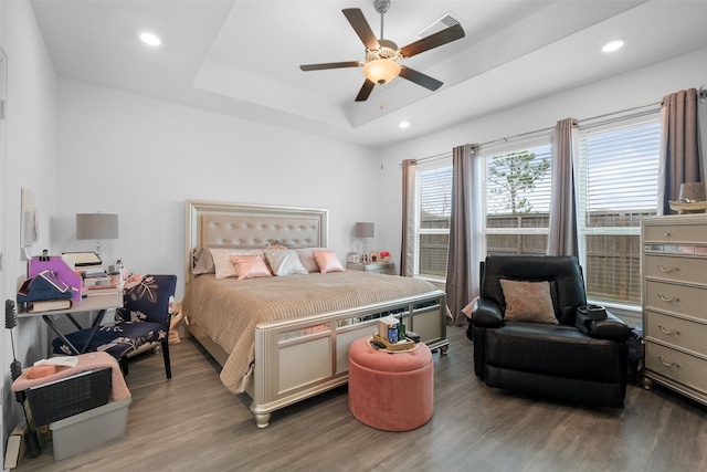 bedroom featuring ceiling fan, hardwood / wood-style flooring, and a raised ceiling