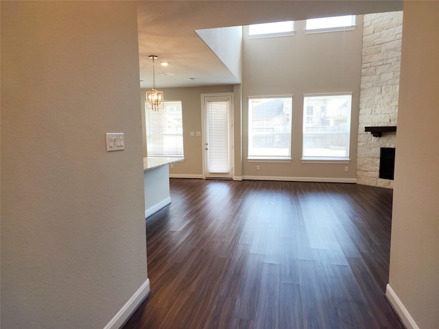 interior space with a notable chandelier, a fireplace, and dark wood-type flooring