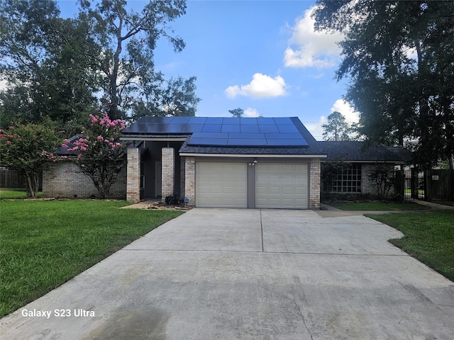 view of front of property featuring a garage, solar panels, and a front yard