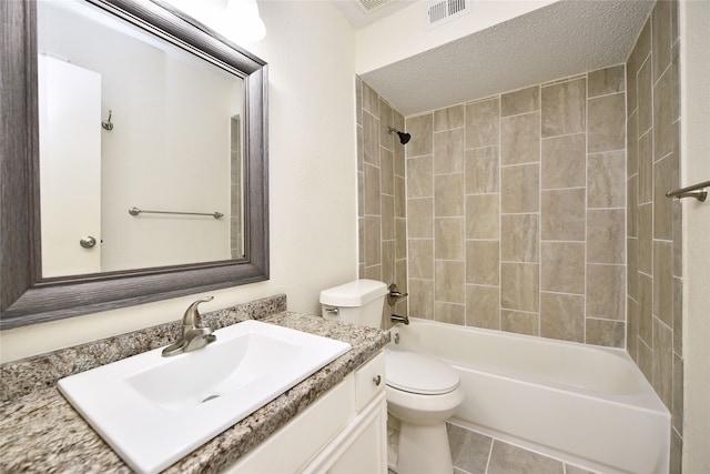 full bathroom featuring vanity, toilet, tiled shower / bath combo, and a textured ceiling