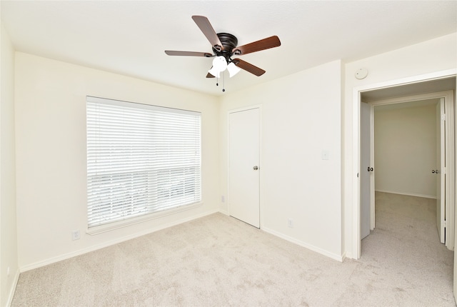 unfurnished bedroom with light carpet, ceiling fan, and a closet