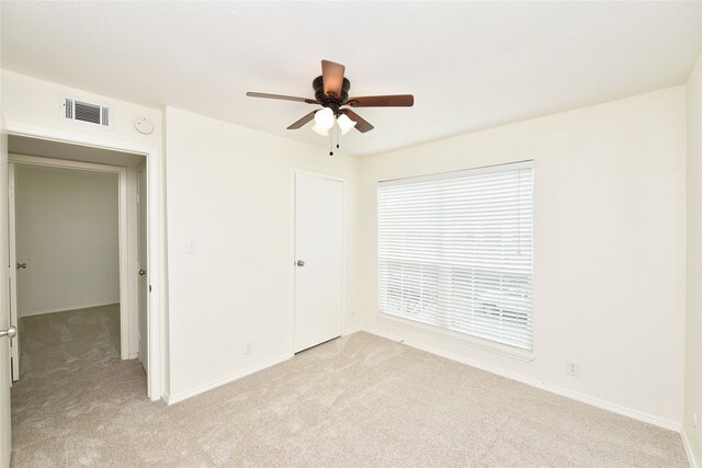 unfurnished bedroom with light colored carpet and ceiling fan