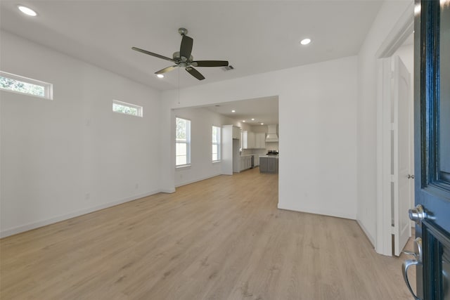 unfurnished living room featuring ceiling fan and light hardwood / wood-style flooring