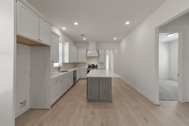 kitchen featuring appliances with stainless steel finishes, a kitchen island, custom exhaust hood, a healthy amount of sunlight, and sink