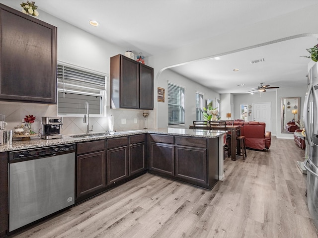 kitchen featuring light hardwood / wood-style floors, dishwasher, decorative backsplash, and ceiling fan