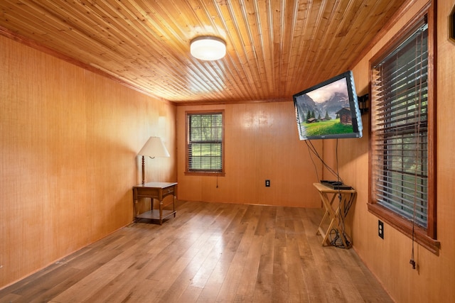 empty room featuring wooden ceiling, wooden walls, and light hardwood / wood-style flooring