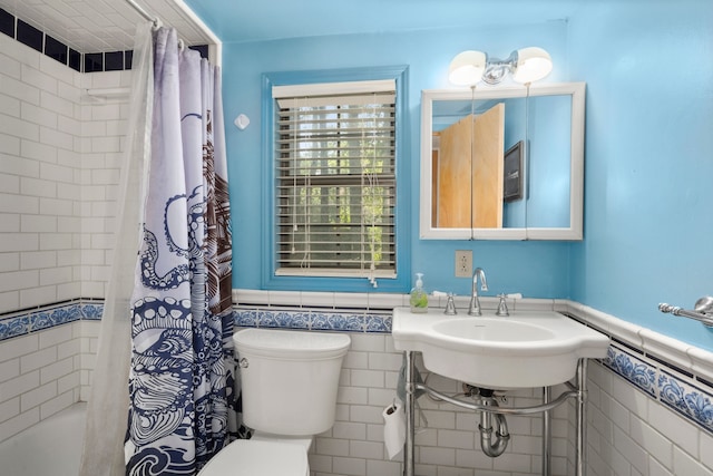 full bathroom with sink, shower / bath combo, tile walls, and toilet