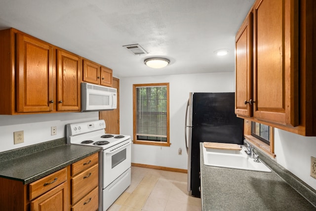 kitchen with sink, light tile patterned flooring, and white appliances