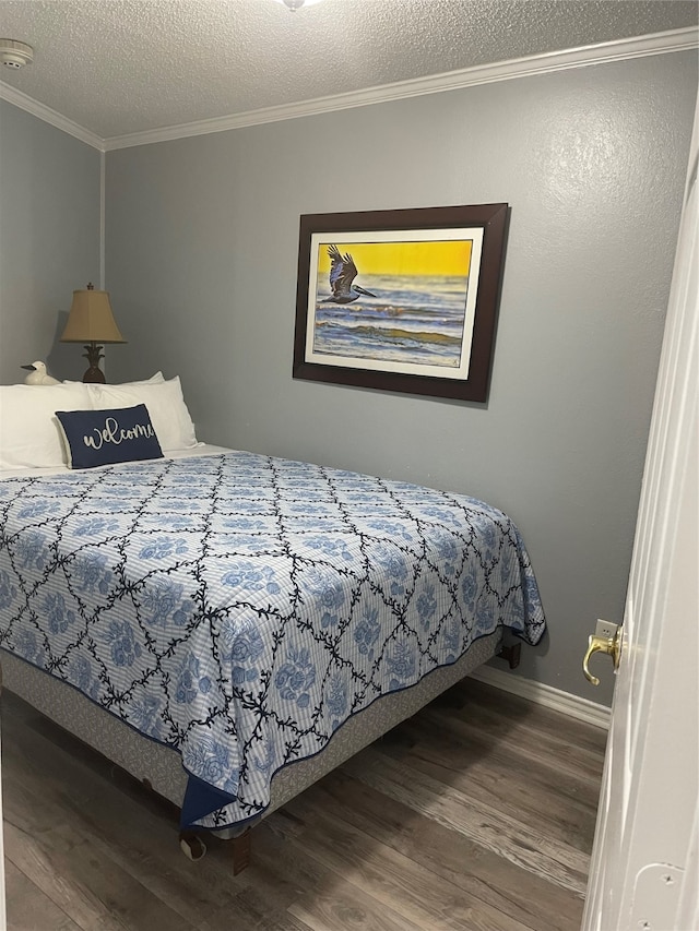 bedroom with ornamental molding, a textured ceiling, and hardwood / wood-style floors