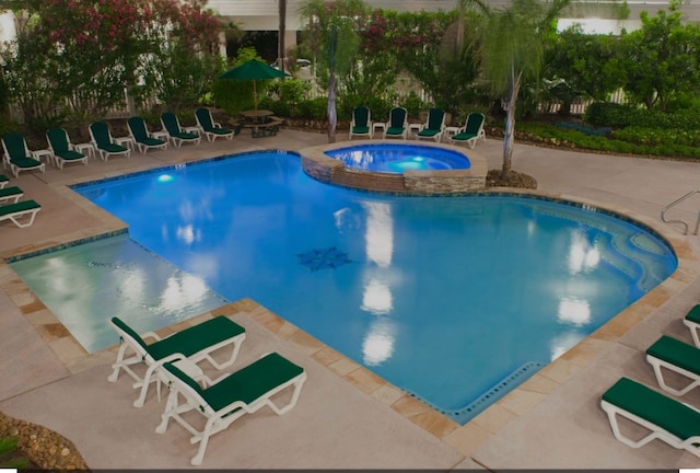 view of swimming pool with a patio and a hot tub