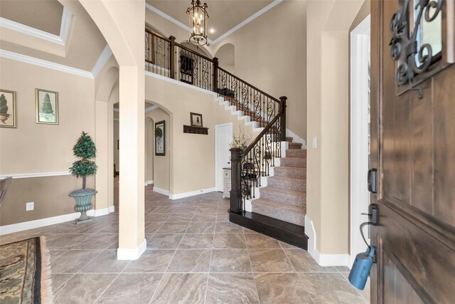 foyer featuring a high ceiling, ornamental molding, and an inviting chandelier