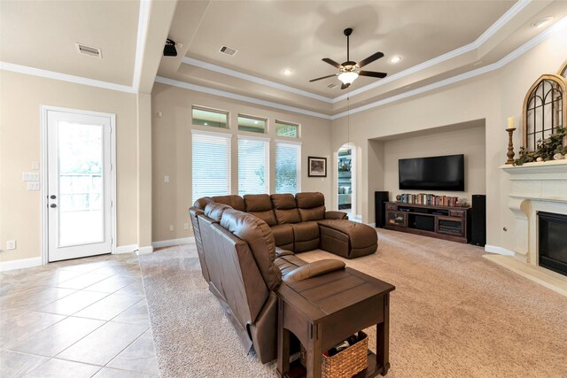 living room featuring ornamental molding, a raised ceiling, and a healthy amount of sunlight