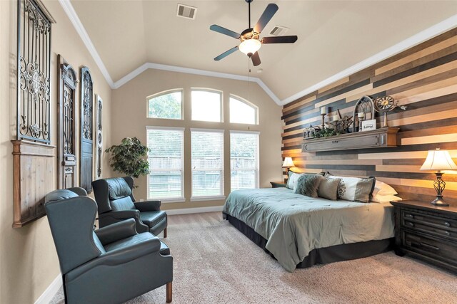 carpeted bedroom with crown molding, ceiling fan, wooden walls, and high vaulted ceiling