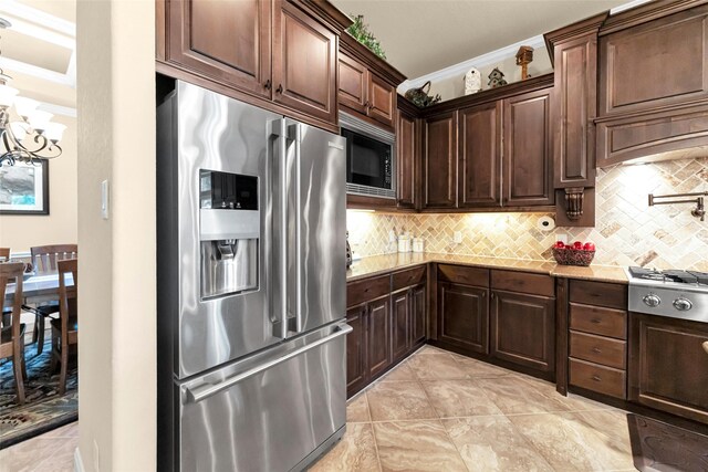 kitchen featuring appliances with stainless steel finishes, light stone counters, dark brown cabinetry, and decorative backsplash