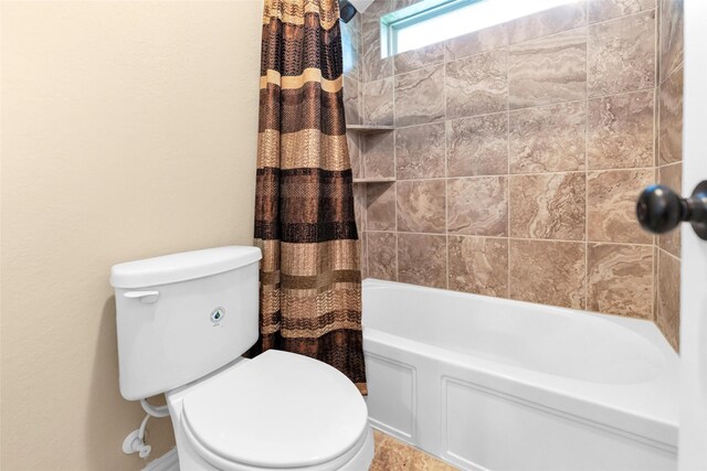 bathroom featuring shower / bath combo and toilet