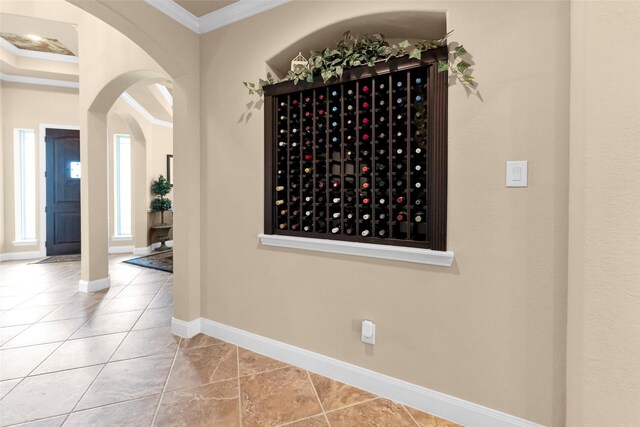 wine cellar with crown molding and light tile patterned floors