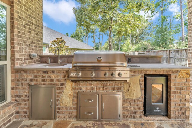 view of patio / terrace featuring sink, grilling area, and an outdoor kitchen