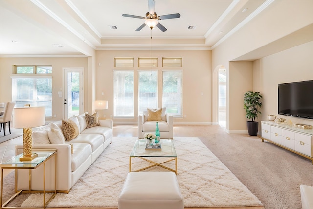 203 Gaillardia Ct, Pinehurst, TX 77362 - carpeted living room featuring a ceiling fan, crown molding, arched walkways, and baseboards