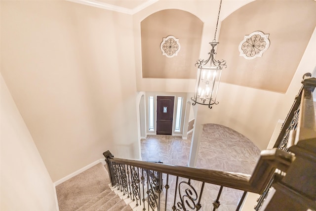 203 Gaillardia Ct, Pinehurst, TX 77362 - staircase with arched walkways, baseboards, a chandelier, a towering ceiling, and crown molding