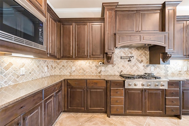 203 Gaillardia Ct, Pinehurst, TX 77362 - kitchen featuring built in microwave, crown molding, stainless steel gas cooktop, decorative backsplash, and light stone countertops
