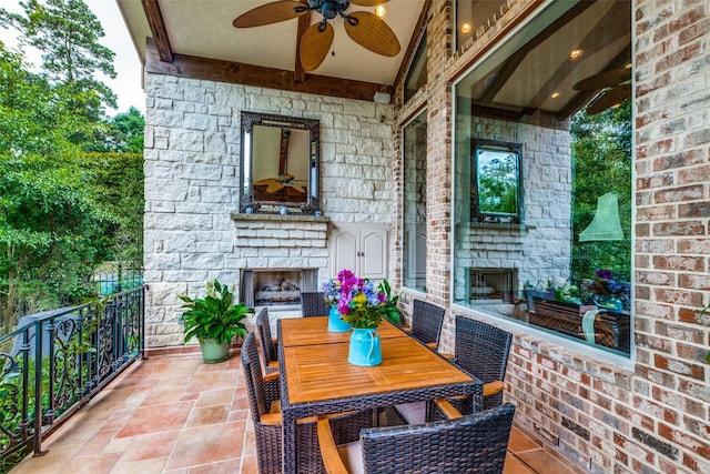 view of patio / terrace with an outdoor stone fireplace and ceiling fan