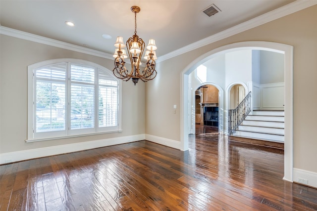 unfurnished room featuring crown molding, dark hardwood / wood-style flooring, and a chandelier