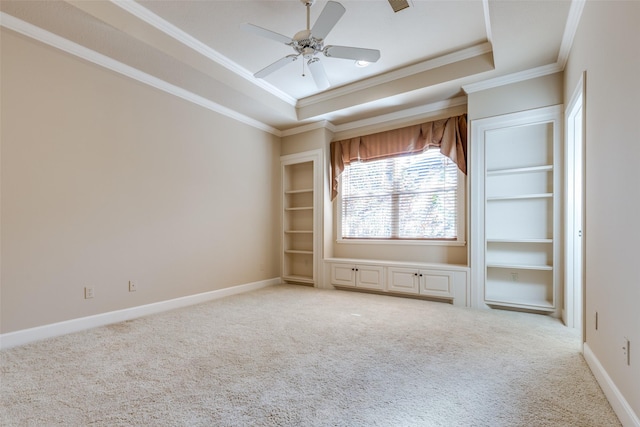 unfurnished bedroom with ceiling fan, a raised ceiling, ornamental molding, and light carpet