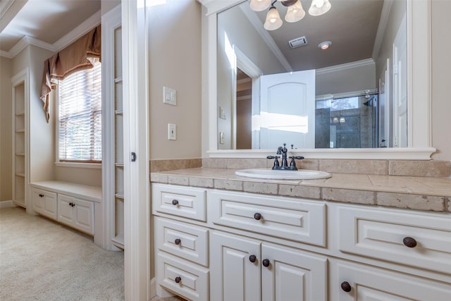 bathroom with vanity, a shower with shower door, and ornamental molding