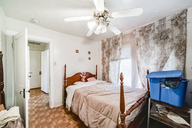 bedroom featuring light parquet floors, a textured ceiling, and ceiling fan