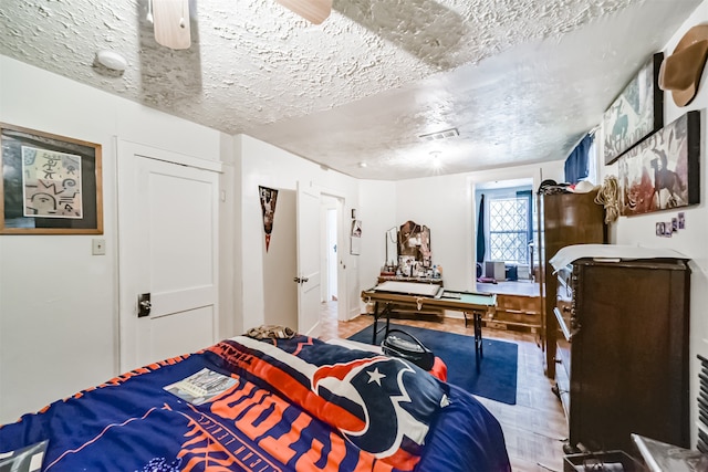 bedroom featuring a textured ceiling, a closet, and light hardwood / wood-style floors