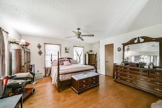 bedroom with a textured ceiling, ceiling fan, and hardwood / wood-style floors