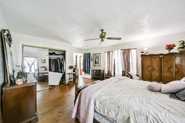 bedroom featuring a textured ceiling, a closet, wood-type flooring, and ceiling fan