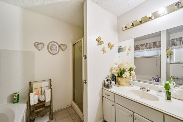 bathroom with tile patterned flooring, separate shower and tub, vanity, and a textured ceiling