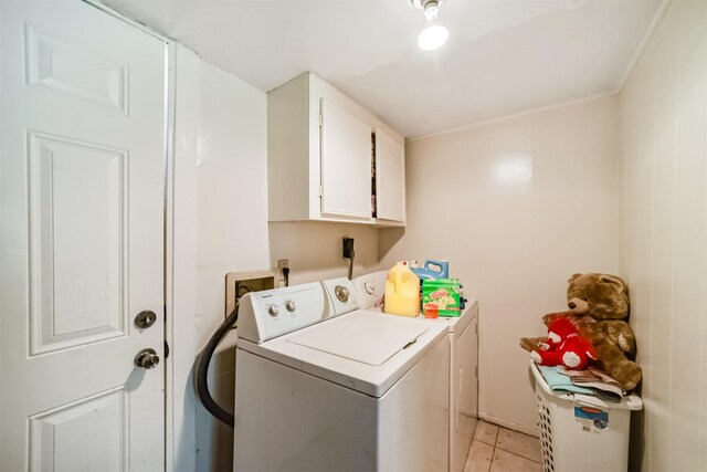 washroom featuring separate washer and dryer, cabinets, and light tile patterned floors