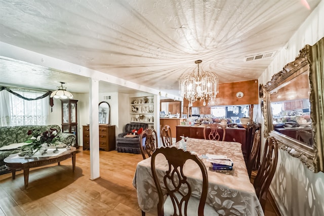 dining area featuring a chandelier and light hardwood / wood-style flooring