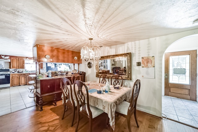 dining area featuring light hardwood / wood-style flooring and an inviting chandelier