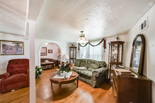 living room with a chandelier and light wood-type flooring