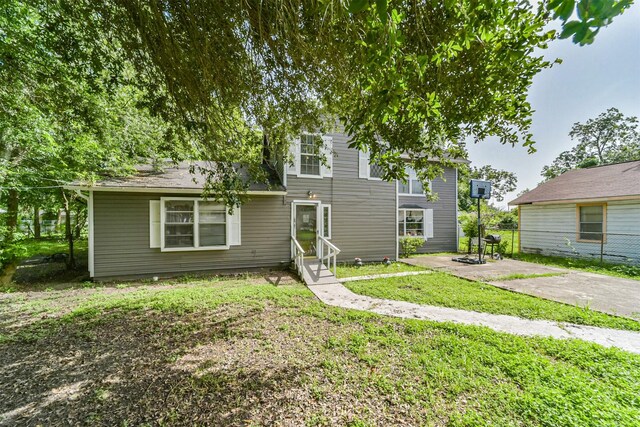 rear view of house featuring a yard