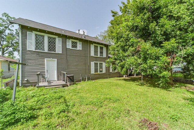 back of property featuring a yard and a wooden deck