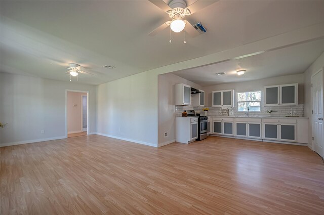 unfurnished living room featuring ceiling fan and light hardwood / wood-style flooring